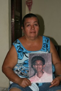 Central American mother holding a picture of her missing son