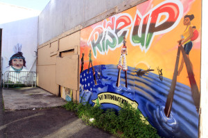 Cultural and political murals cover the walls surrounding the Eastside Arts Alliance on International Boulevard on Wednesday, March 16, 2016 in Oakland, Calif. Students and professional artists team up to create the murals.(Laura A. Oda/Bay Area News Group)