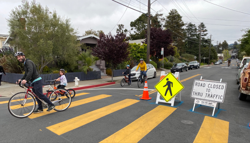 Residents ride bikes near closed street.
