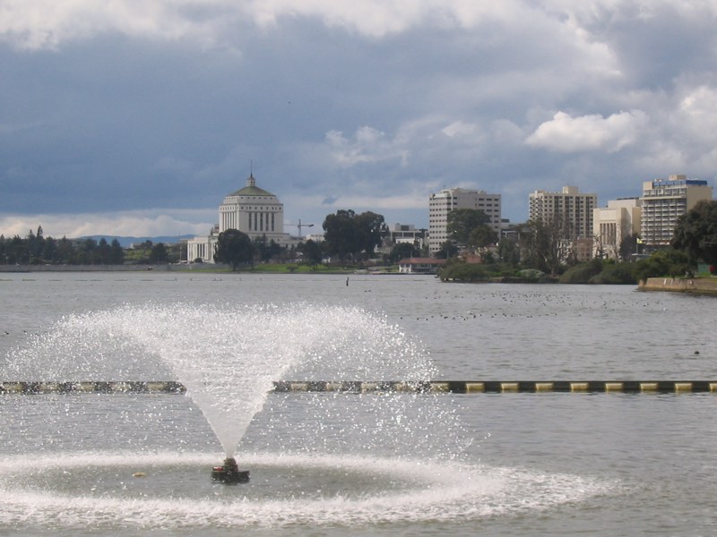 An image of a peaceful, flat lake with a fountain in it.