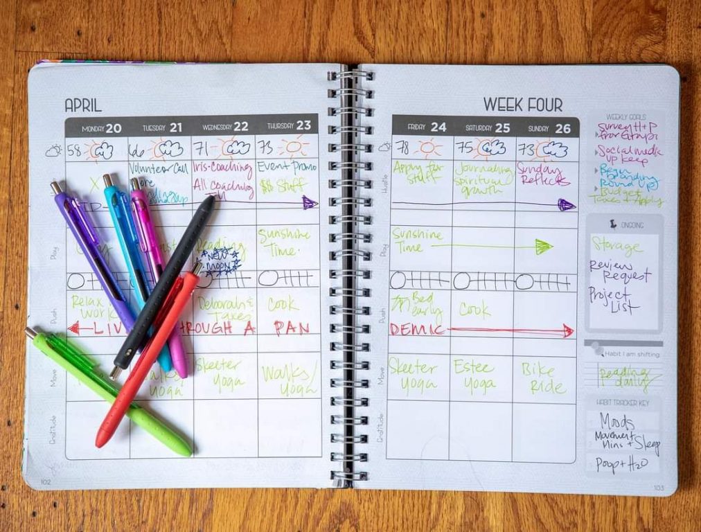 An image of a planner that I open with colorful pens on top.