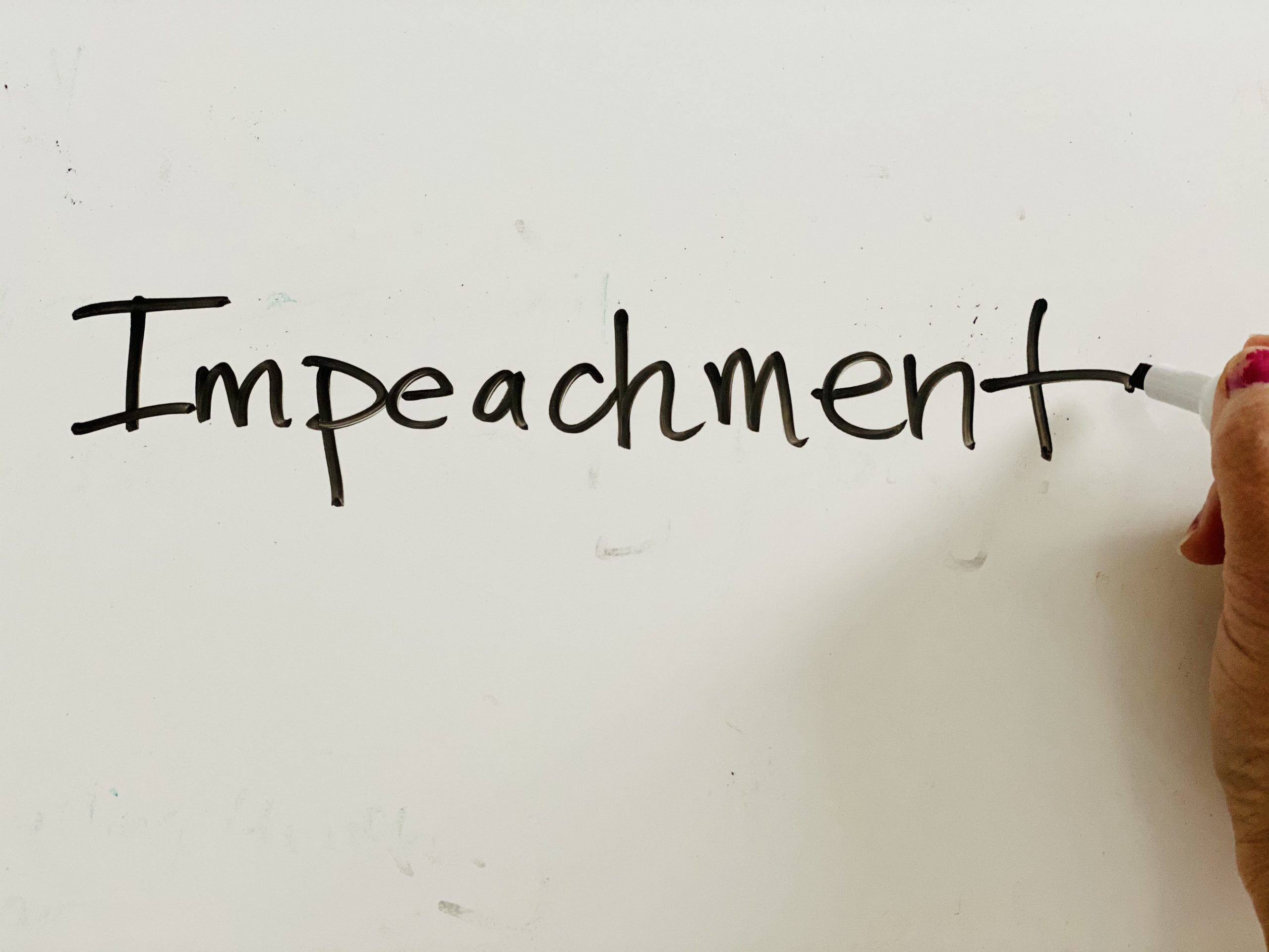 the word "impeachment" written on a white board
