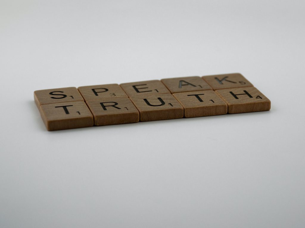 Scrabble tiles against a white background that say "Speak Truth"