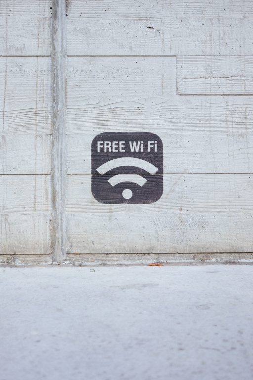 a stencil painting that says "free wifi" against concrete backdrop.
