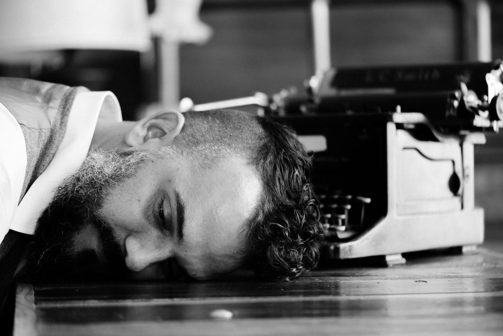 a man puts his head down on the ground in a black and white photo