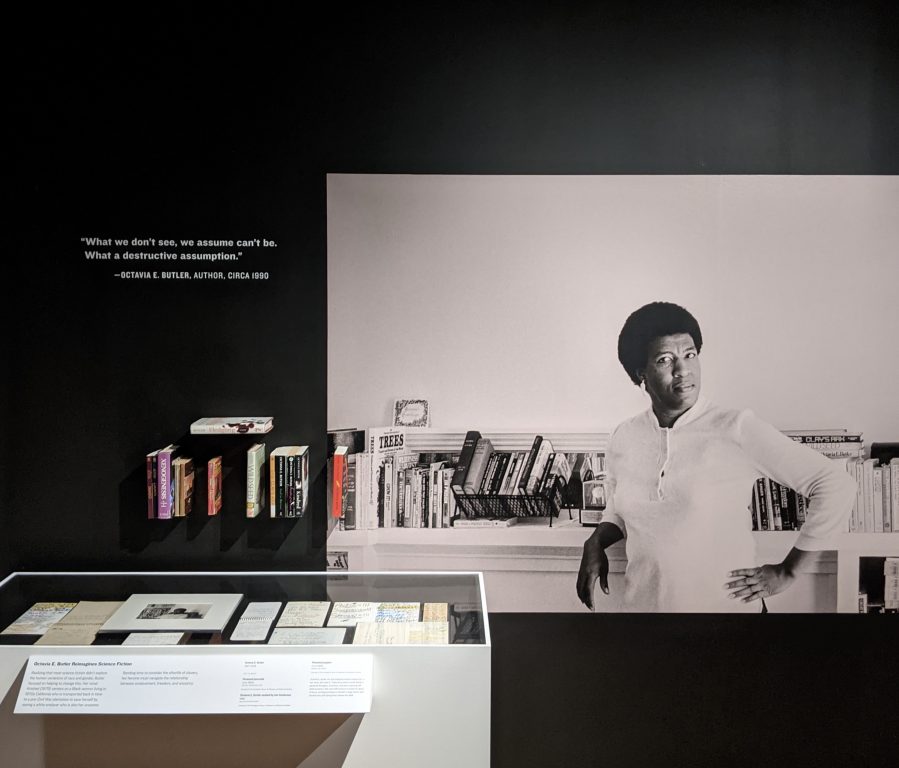 a museum exhibit with a large photo of an African American woman with short hair, writer Octavia Butler.