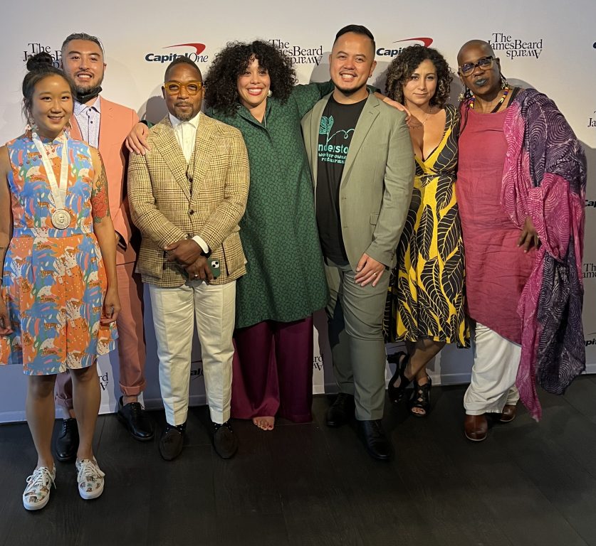a diverse group of chefs from Oakland stand in front of a step and repeat