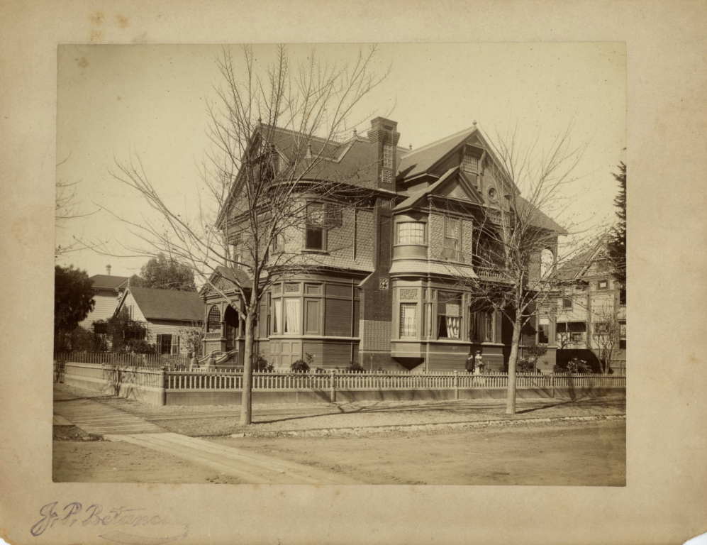 a sepia toned photo of a large Victorian home