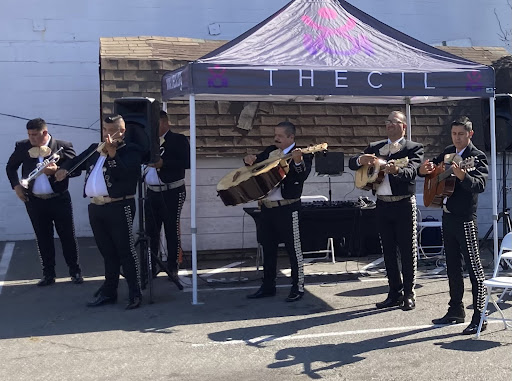 a mariachi band plays under a tent that says "CIL" on the top