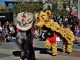 A black and a yellow lion dancer perform outside at Jack London Square