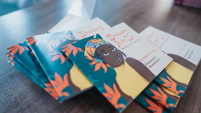 A group of books with an African woman on the cover are on a brightly lit table