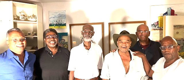 A group of six older Black men pose for a photo