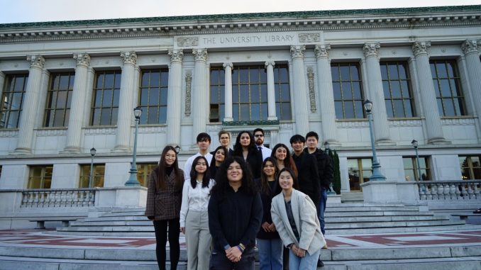 a group of diverse UC Berkeley students stand in front of a big library